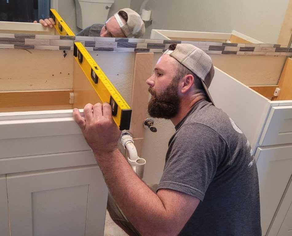 Lining up a level while installing bathroom cabinets